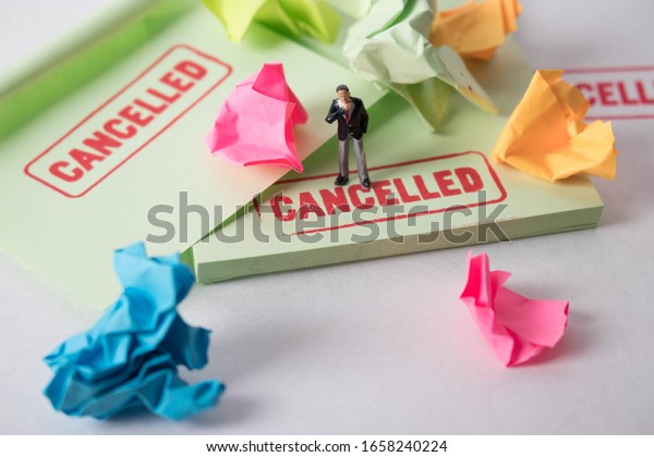 Man with cancelled stamp standing on office\
supplies.  A person is the latest victim of cancel culture.\
Offensive guy labelled by his coworkers. Work politics at a toxic\
workplace. Unhappy\
employees.
