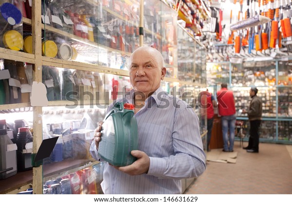  man with\
canister of motor oil in auto\
store