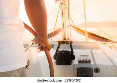 Man As A Captain Sailing Luxury Yacht During Summer Time Golden Sunset In Phuket Island, Thailand