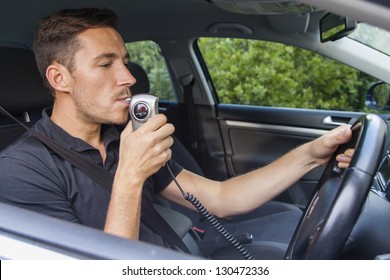 Man In Car Blowing Into Breathalyzer