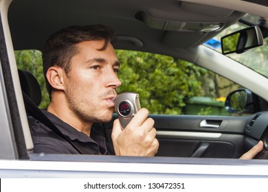 Man In Car Blowing Into Breathalyzer With 0 Reading.