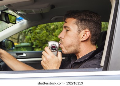 Man In Car Blowing Into Breathalyzer