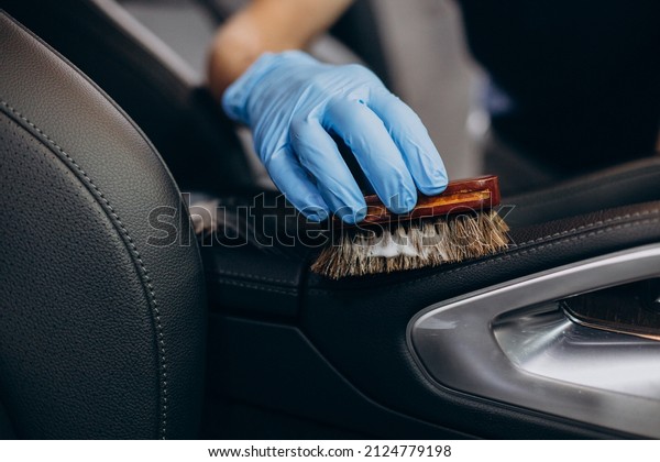 Man at car clean using brush to clean up all\
details inside the vehicle