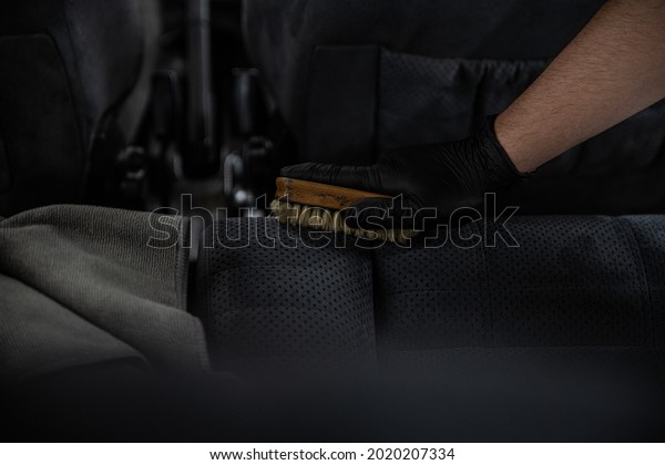 Man car detailing studio worker cleaning
textile car upholstery