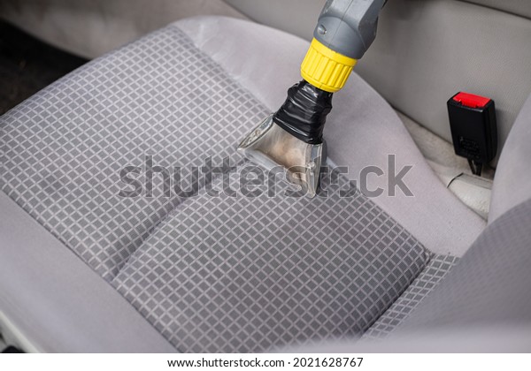 Man car detailing studio worker cleaning car\
textile upholstery