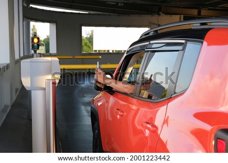 The man in the car, inserts the ticket into the machine in the parking lot. Payment, entering the parking lot or leaving the garage