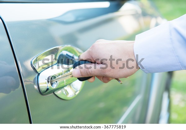 Man with car key outside ,Insert the key (finger\
focused )
