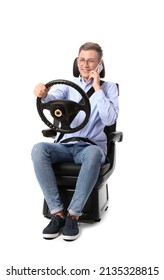 Man In Car Seat And With Steering Wheel Talking By Phone On White Background