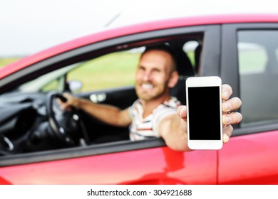 Man In Car Showing Smart Phone Display Smiling Happy. Focus On Mobile Phone.