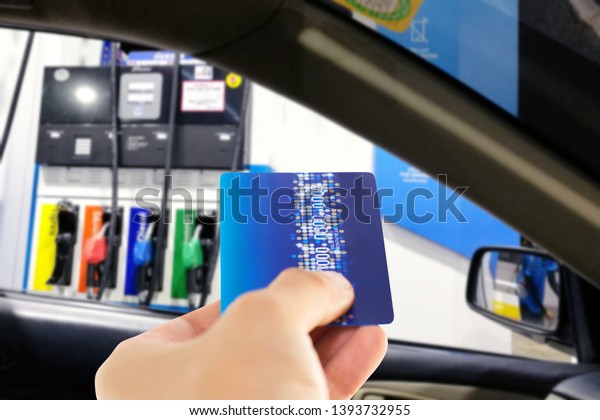 Man in car use credit card to make a payment for\
refueling car on gas\
station