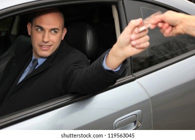 Man In A Car Using A Credit Card