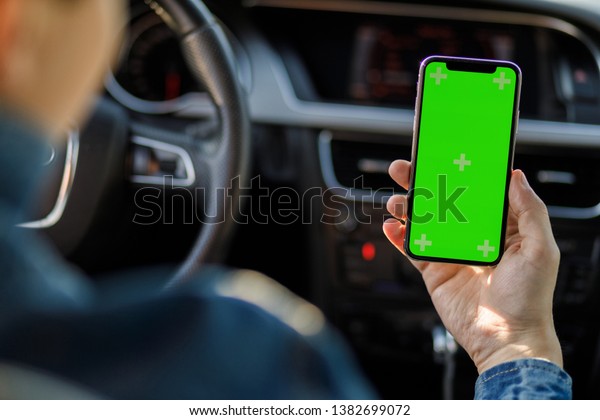 man in the car. Young business man with phone\
in car. Man holding\
smartphone.