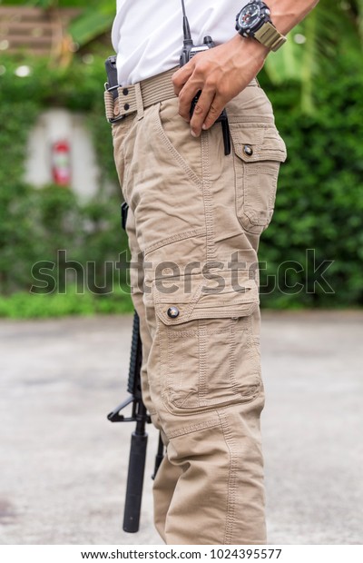 man in cargo pants with\
gun