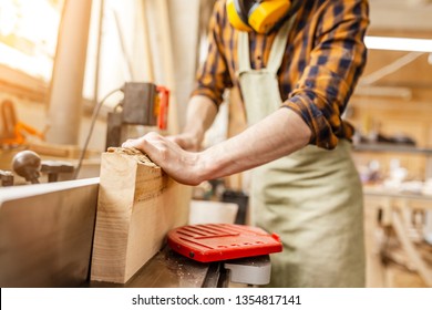 Man carpenter working with wooden workpieces at the construction site. Repair and job concept - Powered by Shutterstock