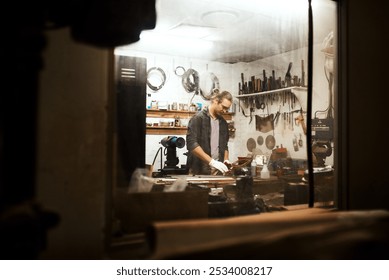 Man, carpenter and workshop with tools for project, deadline or woodwork at manufacture. Young, male person or creative designer with material or equipment for DIY, artisan or crafting on workbench