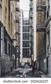 A Man Carries A Box In An Alleyway In Downtown Los Angeles