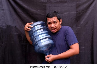 A Man Carries A Gallon Of Water