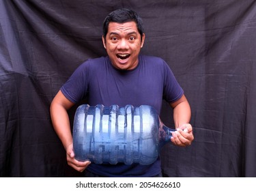 A Man Carries A Gallon Of Water