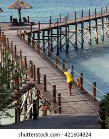 Man Carries Sandbag On Pier In Zanzibar