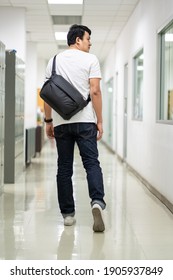 A Man Carry A Black Color Strap Bag On Rear In Office.