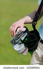 Man Carrying Golf Bag On Golf Course