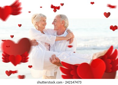 Man carrying his wife on the beach against love heart pattern - Powered by Shutterstock