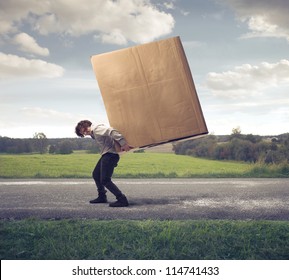 Man Carrying On His Shoulders A Large Box