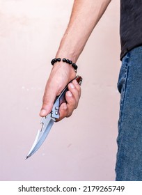 Man Carrying Pocket Knife In Hand And Wearing Bracelet