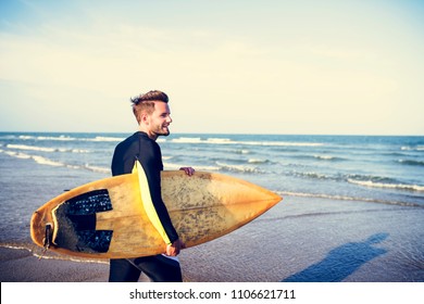 A Man Carrying A Surfboard