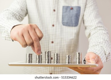 A man carrying a tablet and stacking coin on the screen