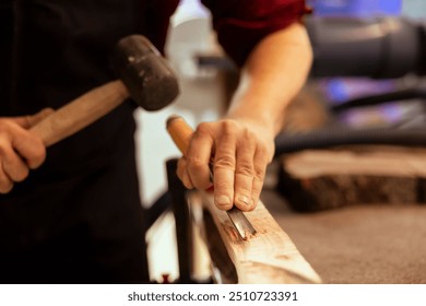 Man carving intricate designs into wood using chisel and hammer in carpentry shop, enjoying diy hobby. Woodworking specialist in studio shaping wooden pieces with tools, making wood art, close up shot - Powered by Shutterstock