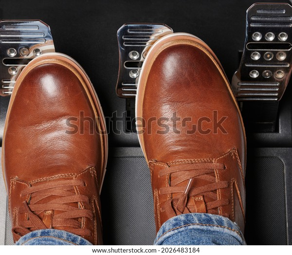 Man in casual brown leather shoes press car pedal\
above top view