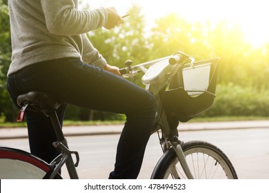 Man in casual clothes riding bike and focuses on phone - Shutterstock ID 478494523
