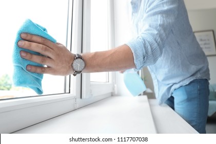 Man In Casual Clothes Washing Window Glass At Home