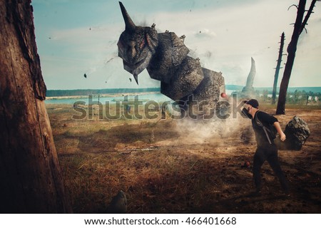 Man catching a stone monster in real life outdoors. creative photo of real monster. monster in real life.
