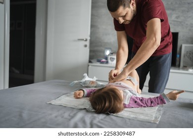 man caucasian father change diapers to his daughter toddler in bedroom - Powered by Shutterstock