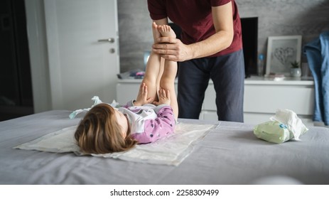 man caucasian father change diapers to his daughter toddler in bedroom - Powered by Shutterstock