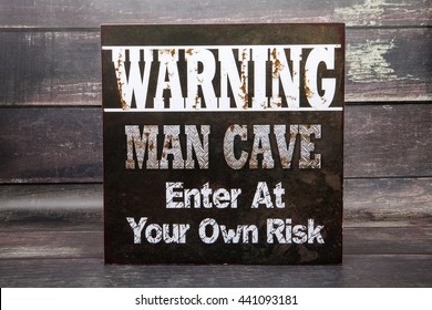 A Man Cave Novelty Sign Against A Wood Background