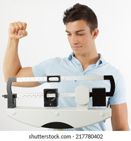 Man Celebrating On A Medical Weight Scale Raising An Arm.