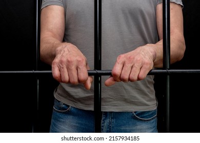 The Man In The Cell Put His Hands On The Bars. Concept: A Prisoner In A Courtroom, A Court Sentence To A Convicted Person, A Prison Term.