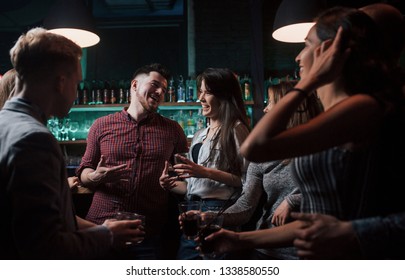 Man Is In The Center Of Everyone's Attention. Beautiful Youth Have Party Together With Alcohol In The Nightclub.