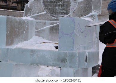 A Man With A Chainsaw Cuts A Piece Of Ice For The 2021 Quebec Carnival
