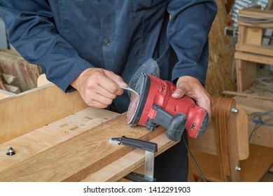 
A Man Changes The Abrasive Wheel On A Grinding Machine