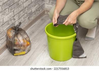 A Man Changes A Garbage Bag In A Bucket. Woman Tearing Off A Trash Bag