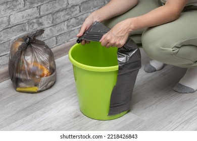 A Man Changes A Garbage Bag In A Bucket. Woman Tearing Off A Trash Bag. High Quality Photo