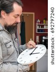 a man changes the time on a clock, daylight savings or change return to standard time