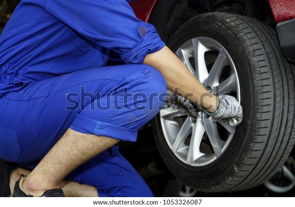 Man changes tire of car man unlocks tire of a car\
for service