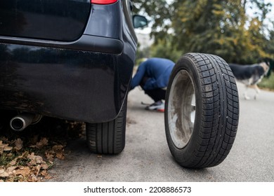 A man changes a wheel after a car breaks down. Transport, travel concept - Shutterstock ID 2208886573