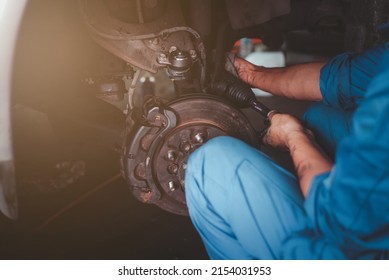 man changes a wheel hub with a wheel bearing in a car, Car disk brake pad replacement service by hand of mechanic man in car garage with flare light effect and copy space - Shutterstock ID 2154031953