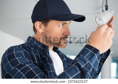 man changing bulb in spotlight